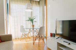 波尔图Oporto Yellow Apartments的客厅配有桌椅和电视