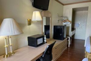 胡尔伯克霍尔布鲁克旅程住宿酒店的客房设有一张带电视和台灯的书桌。