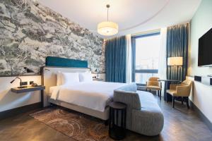 格拉斯哥格拉斯哥丽笙酒店的配有一张床和一把椅子的酒店客房