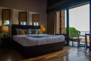 瓦都瓦Inidi Leisure Luxury Villas的一间带大床的卧室和一个阳台