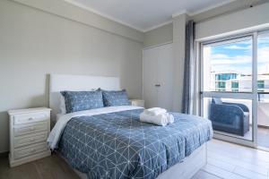 阿玛考德佩拉Beachfront apartment in Armação的一间卧室设有一张床和一个大窗户