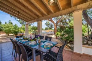 坎皮卡福特Ideal Property Mallorca - Can Ribas的庭院设有餐桌、椅子和木制天花板