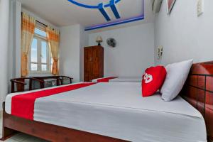 岘港OYO 998 Loan Anh 2 Hotel的一间卧室配有一张带红色和白色枕头的大床