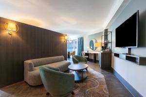 格拉斯哥格拉斯哥丽笙酒店的酒店客房设有沙发、椅子和电视。