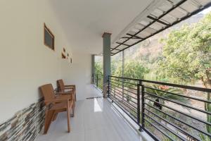 西洛瓦RedDoorz near Ciletuh Sukabumi的客房设有带椅子的阳台,享有美景。