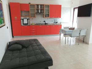 坎波巴索Pirandello45 - zona universitaria的厨房配有红色橱柜和桌椅