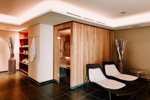 斯图加特Vienna House Easy by Wyndham Stuttgart的一间带两把椅子和衣柜的用餐室