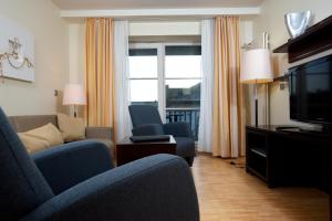 韦斯特兰Hapimag Resort Aalborg的客厅配有沙发、椅子和电视