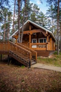 OzerkiSea Home Cottages的树林中的小木屋,设有大甲板