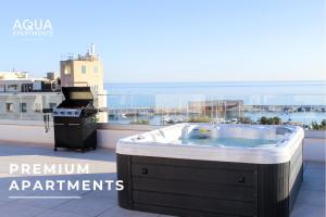 马贝拉Aqua Apartments Bellamar, Marbella的阳台上的热水浴缸和烧烤架