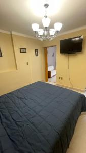 苏克雷Bernardo’s Departamento céntrico para 2 o hasta 3 personas的一间卧室配有蓝色的床和一台平面电视