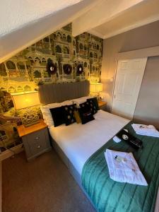 布莱克浦Delovely Hotel的一间卧室配有一张大床和一张带床罩的书桌