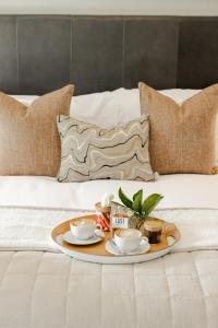 Simondium韦乐德恩鲁斯特艾斯塔特酒店的床上的盘子,上面有杯子和碟子