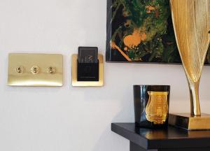 萨格勒布Note Luxury Apartments的一张桌子,上面有金花瓶,墙上有时钟