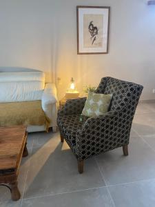 塞维利亚Casa unifamiliar FIBES的一间卧室配有一张床和一把带枕头的椅子