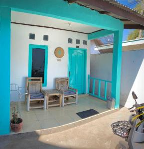 吉利特拉旺安Salt Life Gili Trawangan的门廊配有两把椅子和一扇蓝色的门