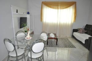 波苏斯-迪卡尔达斯Apto com 3 quartos,1 vaga garagem e quintal的客厅配有玻璃桌和椅子