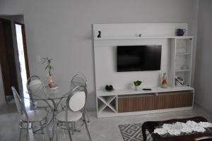 波苏斯-迪卡尔达斯Apto com 3 quartos,1 vaga garagem e quintal的客厅配有桌椅和电视。