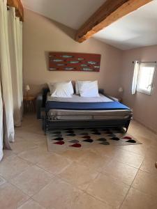 勒博塞Domaine de La Font des Pères - Teritoria的一间卧室配有一张带蓝色床单和地毯的床。