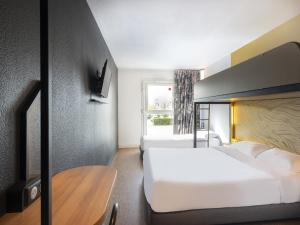绍莱B&B HOTEL Cholet Nord的酒店客房设有两张床和一张桌子。