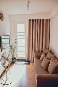 达沃市AiPad Condo Rentals的带沙发和风扇的客厅