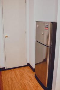 达沃市AiPad Condo Rentals的冰箱在房间的角落