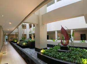 玛琅Savana Hotel & Convention Malang的大楼里有一个有植物和灯的大堂