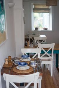 奥尔德尼The Victoria的餐桌,配有白色椅子和蓝色及白色的菜肴