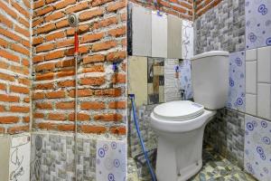 KalasanOYO Life 93010 Omah Bareng Syariah Sambisari的一间带卫生间和砖墙的浴室