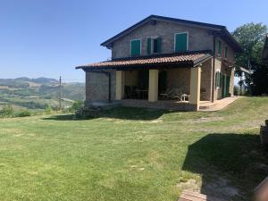 萨韦纳河畔圣拉扎罗Casale IL SAMBUCO sui colli bolognesi的一座带大院子的山丘上的房子