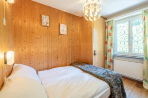 莱克斯LAAX Homes - Casa Gronda 2的一间带木墙的卧室和一张位于客房内的床