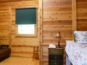壹岐市Shimanologhouse - Vacation STAY 41662v的卧室设有木墙、窗户和床。