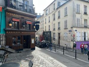 巴黎Appartement Montmartre Sacré Cœur的街道上拥有建筑和人行道的城市街道