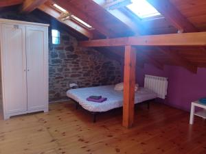 CellerueloCasa típica asturiana en Ribota的阁楼上设有一张床铺的房间,设有窗户