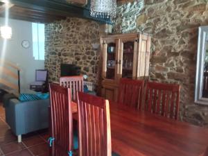 CellerueloCasa típica asturiana en Ribota的一间设有桌椅和石墙的用餐室