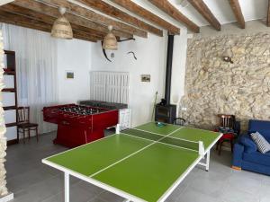 Las CabanyasCal Tomaset的客厅设有一张乒乓球桌和石墙