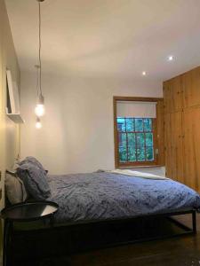 麦克尔斯菲尔德Cosy Cottage (Free parking)的一间卧室配有一张床、一张桌子和一个窗户。
