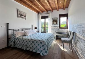 SobremazasApartamentos Rurales Sobremazas的卧室配有1张床、1张桌子和1把椅子