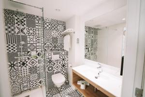 蒙斯Utopia Hotel - Art & Nature Hotel的浴室设有黑色和白色的瓷砖墙