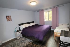 安吉利斯港PA Sea View Deck House的一间卧室设有紫色的床和窗户