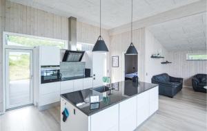 格莱斯堡Beautiful Home In Glesborg With Kitchen的厨房配有白色橱柜和黑色台面
