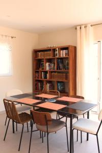 旺德尔港Villa plain pied vue terrasse的一间带桌椅和书架的用餐室