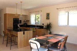 旺德尔港Villa plain pied vue terrasse的厨房以及带桌椅的用餐室。