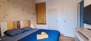 莱萨布勒-多洛讷CANTETEAU - Agreable maison chaleureuse et conviviale的一间卧室配有蓝色的床和2条毛巾