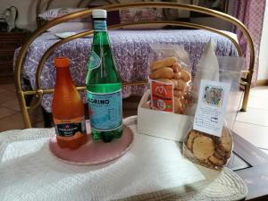圣佩莱格里诺温泉Casa Marina的桌子上放着两瓶苏打水和面包