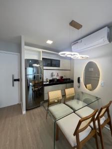 圣路易斯Luxuoso Apartamento na Ponta da Areia的用餐室以及带玻璃桌和椅子的厨房