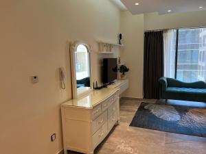 安曼Luxury Studio DAMAC TOWER - 1 BEDROOM -JORDAN的一间设有镜子和电视的梳妆台的房间