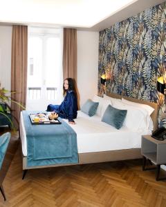 罗马卡拉维塔酒店的坐在酒店房间床上的女人