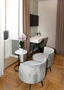 罗马卡拉维塔酒店的客厅配有两把椅子和一张桌子