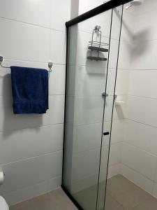 莫索罗Studio no West Fit Mossoró Alto Padrão的浴室里设有玻璃淋浴间,备有蓝色毛巾